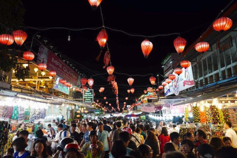 Một nhóm người dân địa phương hoặc du khách đang cùng nhau thưởng thức rượu sim trong không khí vui vẻ